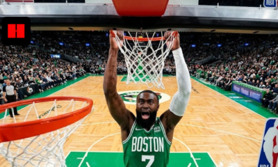 Boston Celtics guard Jaylen Brown performing a powerful two-handed slam dunk seen from a wide-angle backboard camera during an NBA game.