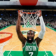 Boston Celtics guard Jaylen Brown performing a powerful two-handed slam dunk seen from a wide-angle backboard camera during an NBA game.