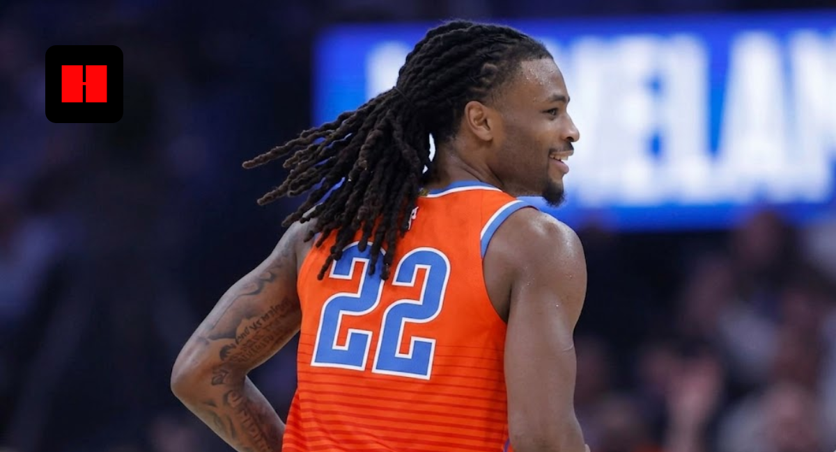 Oklahoma City Thunder guard Cason Wallace (number 22) smiling on court during an NBA game, wearing the orange Statement Edition jersey with his signature long dreadlocks in motion.
