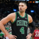 NBA center Nikola Vučević wearing a black Boston Celtics Statement Edition jersey with number 4, standing on the court during a game against the Miami Heat.