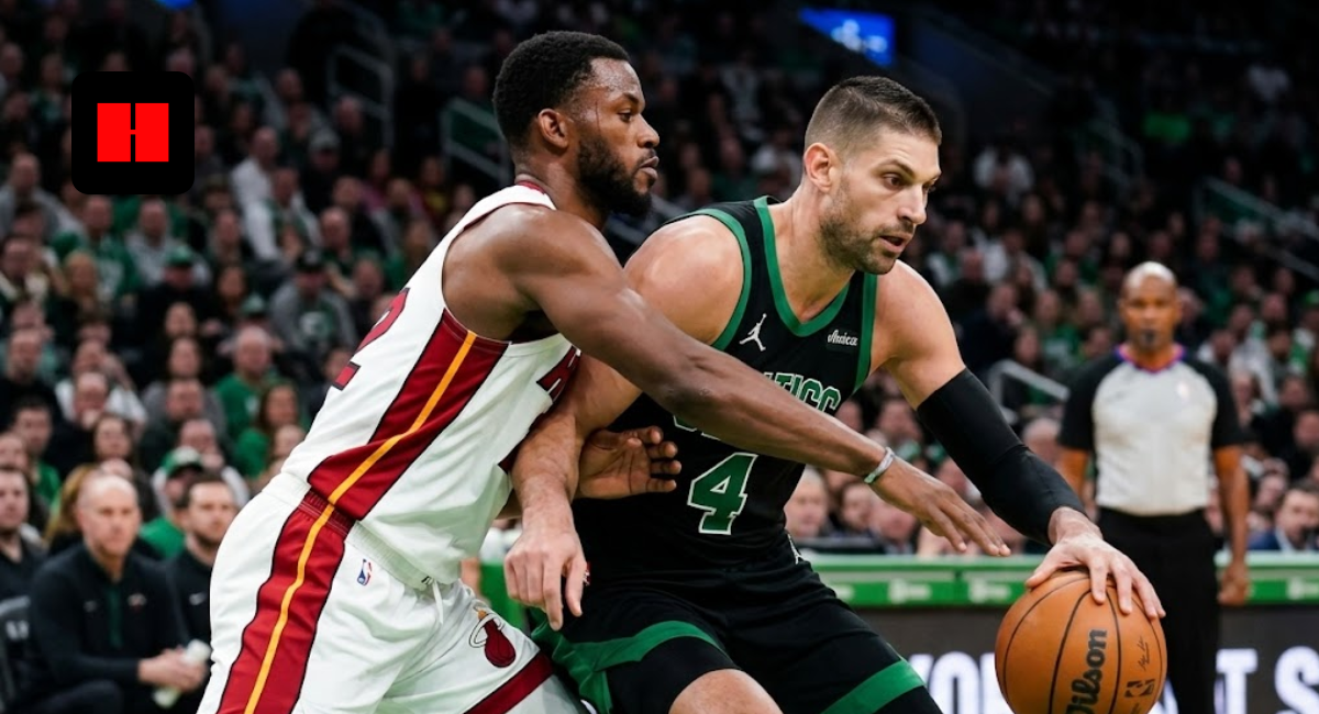 Boston Celtics center Nikola Vucevic (4) drives to the basket while being defended by a Miami Heat player in a packed arena during a 2026 regular season game.
