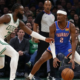 Oklahoma City Thunder’s Shai Gilgeous-Alexander (#2) maintains a low-gravity dribble while being closely guarded by Boston Celtics’ Jaylen Brown during a high-intensity NBA game.