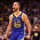 Stephen Curry roaring in Warriors uniform during high intensity NBA game action shot wide banner