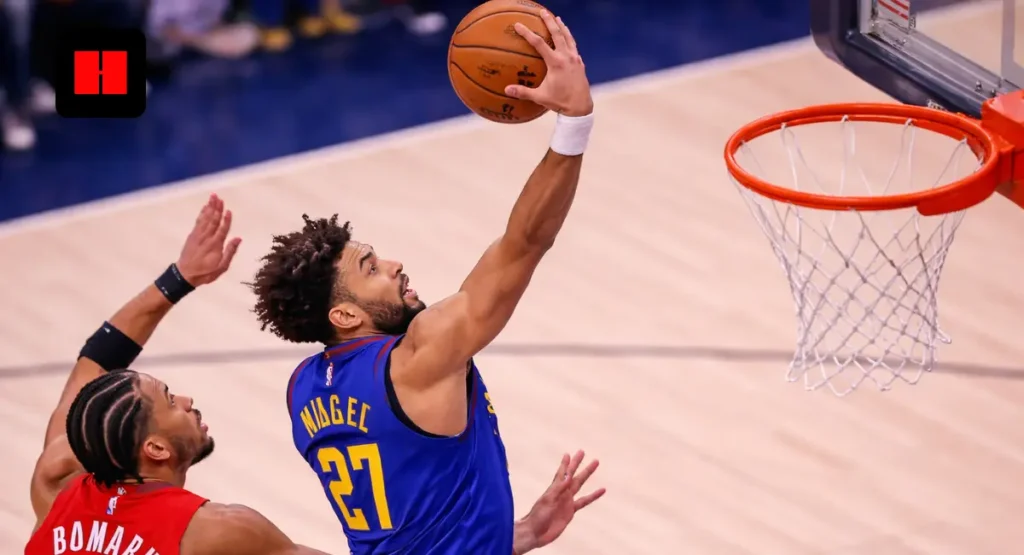 **Alt text:**
Denver Nuggets guard drives for a one-handed layup from an overhead angle while a Toronto Raptors defender contests at the rim during an NBA game.
