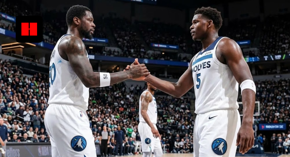 Anthony Edwards and Julius Randle of the Minnesota Timberwolves shaking hands during a basketball game on the court in their white home uniforms.
