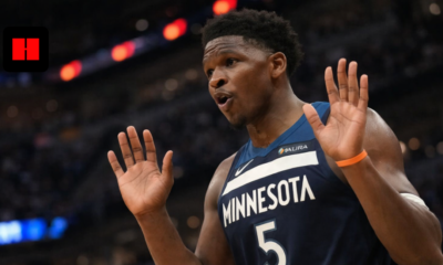 Anthony Edwards of the Minnesota Timberwolves reacts with both hands raised during an NBA game in a crowded arena