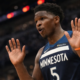 Anthony Edwards of the Minnesota Timberwolves reacts with both hands raised during an NBA game in a crowded arena
