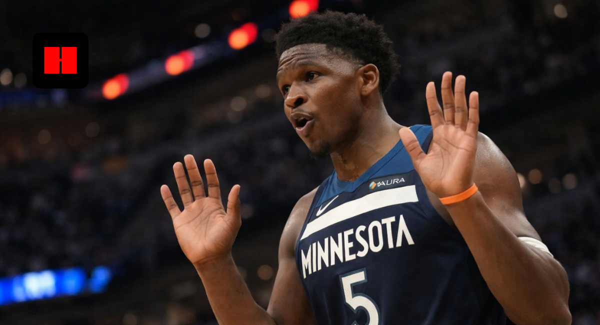 Anthony Edwards of the Minnesota Timberwolves reacts with both hands raised during an NBA game in a crowded arena