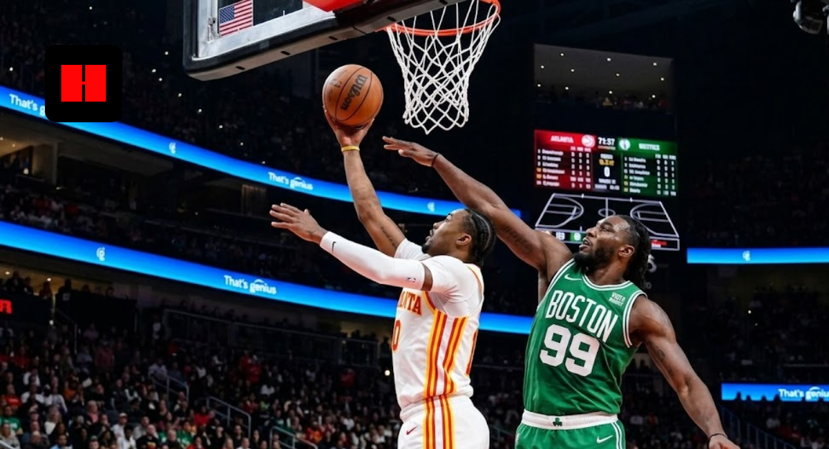 Atlanta Hawks player in white jersey number 0 drives for a layup against Boston Celtics defender number 99 in a crowded NBA arena.