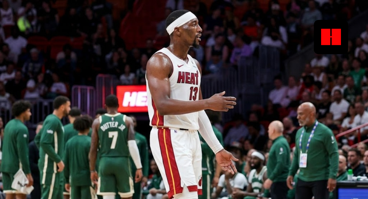Miami Heat center Bam Adebayo wearing a white jersey and headband, gesturing on the basketball court during an NBA game.