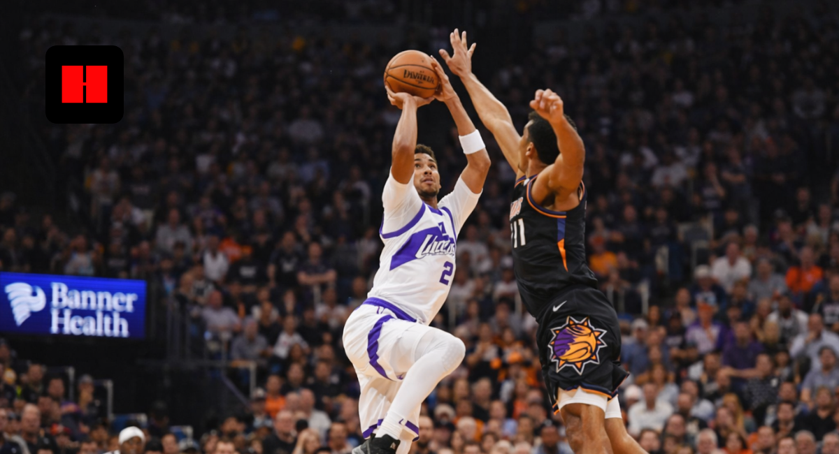 Basketball player taking a jump shot while defender contests the shot during a live game