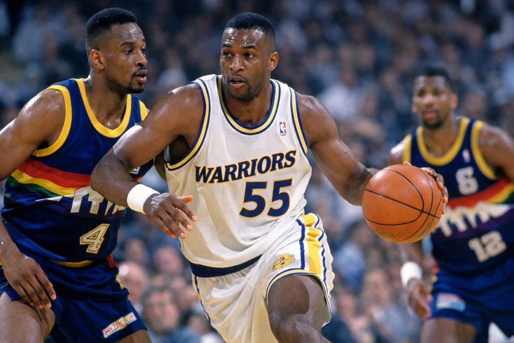 Billy Thompson of the Golden State Warriors dribbles past a defender during a 1992 game, wearing jersey number 55 in a classic early-90s matchup against the Denver Nuggets.