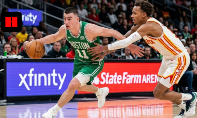 Boston Celtics point guard driving to the basket while being defended by an Atlanta Hawks player during an NBA game.