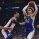 Brandin Podziemski of the Warriors looks to pass while surrounded by New York Knicks defenders during an NBA game in New York.