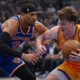 Charlotte Hornets player protecting the ball against New York Knicks defender during NBA game action
