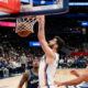 Chet Holmgren of the Oklahoma City Thunder performs a powerful one-handed dunk over Anthony Gill of the Washington Wizards during an NBA game.