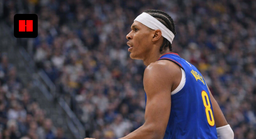 Professional basketball player in blue jersey captured from side angle during live game with crowd background