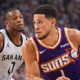 Devin Booker dribbling the basketball against San Antonio Spurs defender during an NBA game in high resolution.