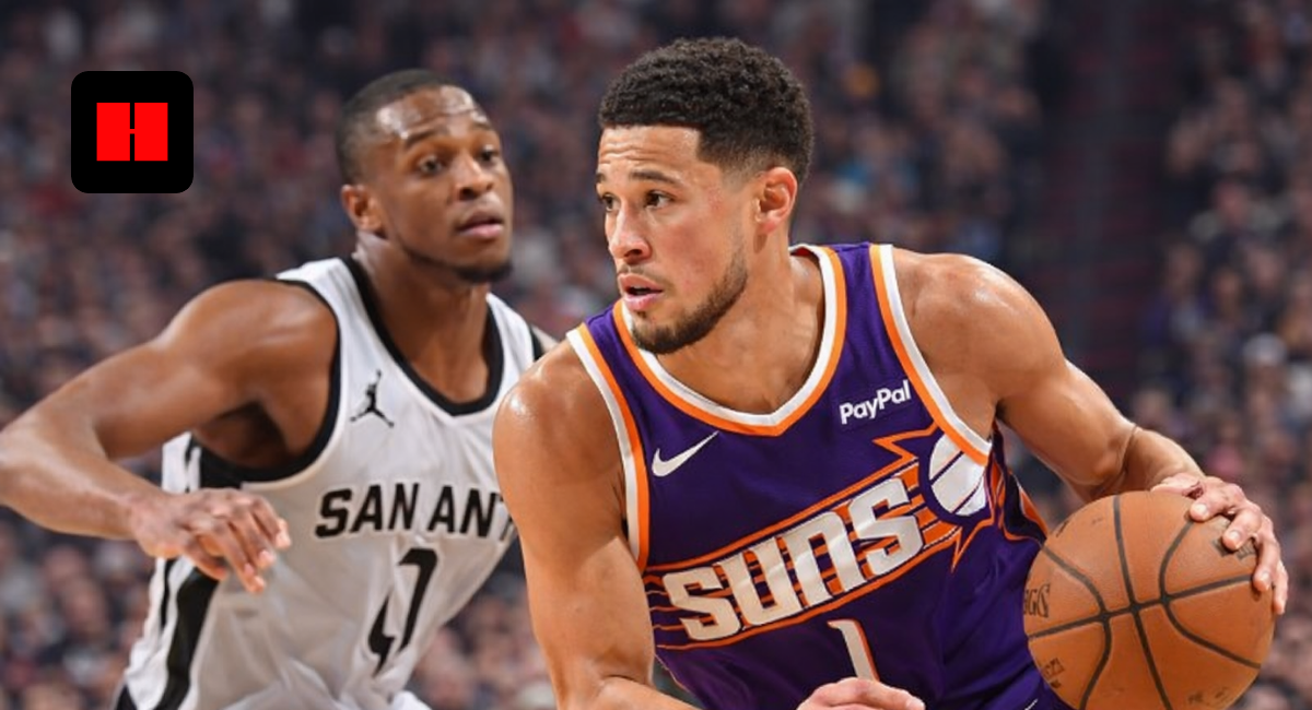 Devin Booker dribbling the basketball against San Antonio Spurs defender during an NBA game in high resolution.