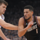 Devin Booker dribbling the basketball against Los Angeles Clippers defender during NBA game