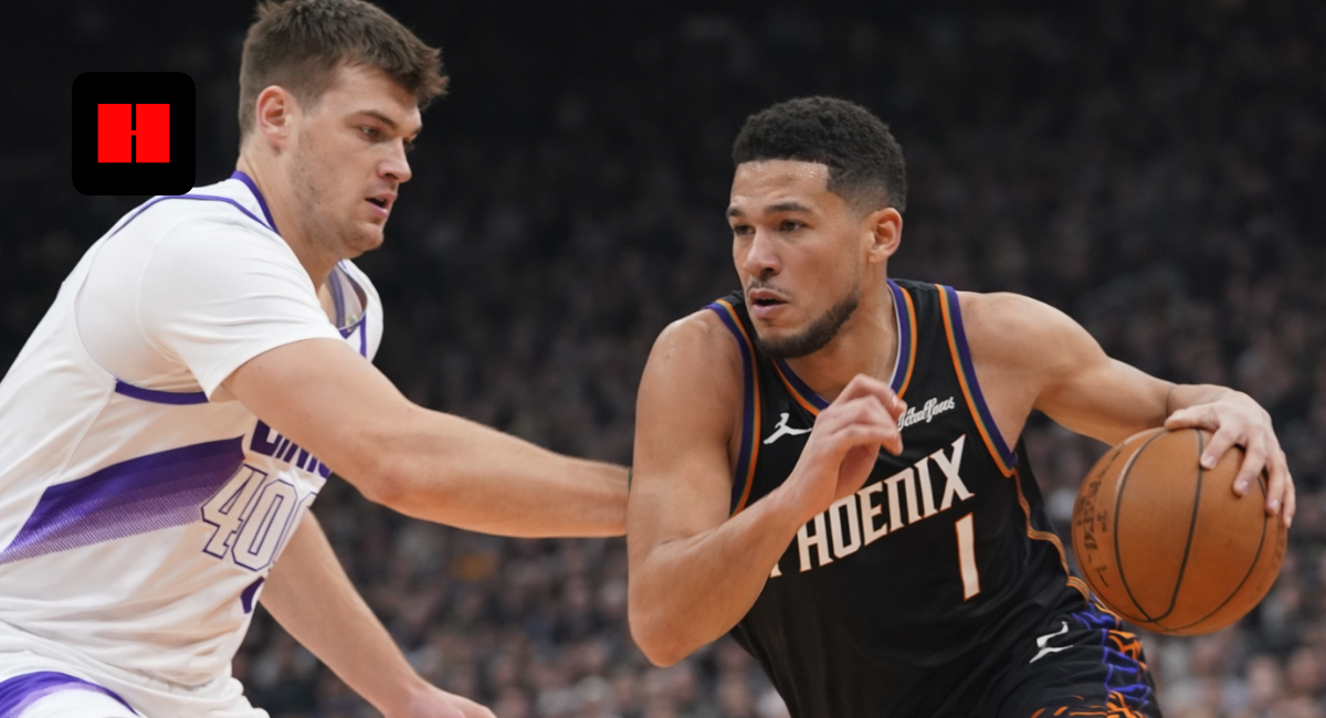 Devin Booker dribbling the basketball against Los Angeles Clippers defender during NBA game