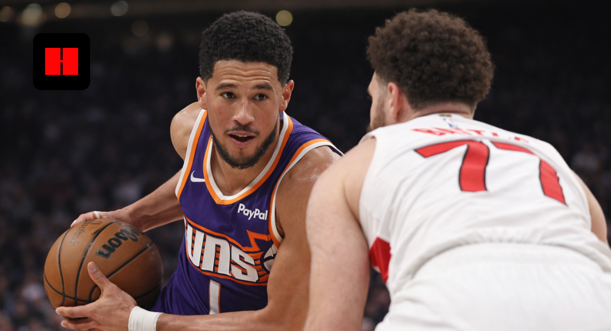 Devin Booker of the Phoenix Suns drives past a Toronto Raptors defender during an NBA game, showcasing ball control and offensive pressure in UHD action shot.