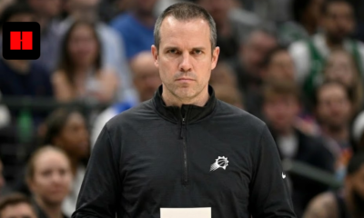 Frank Vogel, head coach of the Phoenix Suns, standing on the sidelines holding a play card during an NBA game.