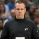 Frank Vogel, head coach of the Phoenix Suns, standing on the sidelines holding a play card during an NBA game.
