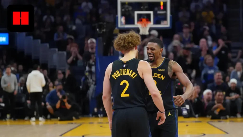 Brandin Podziemski celebrates with Gary Payton II during a Golden State Warriors game as teammates connect on the court in front of the home crowd.