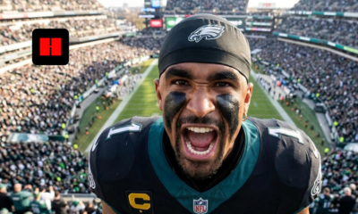 High-angle shot of Jalen Hurts yelling intensely at the camera in a crowded Eagles stadium.
