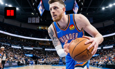 Isaiah Hartenstein of the Oklahoma City Thunder handles the ball during a live game, focused in the half-court offense with defenders closing in and crowd in the background