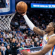 Oklahoma City Thunder forward Jalen Williams performing a finger-roll layup during an NBA game, side profile view.