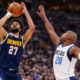 Jamal Murray takes a contested jump shot for the Denver Nuggets against Dallas Mavericks defender during NBA game
