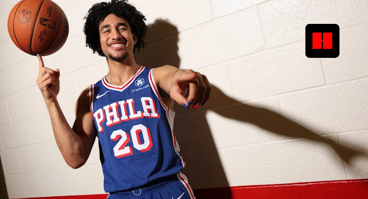 Jared McCain in Philadelphia 76ers jersey spins basketball on finger during media day photo shoot