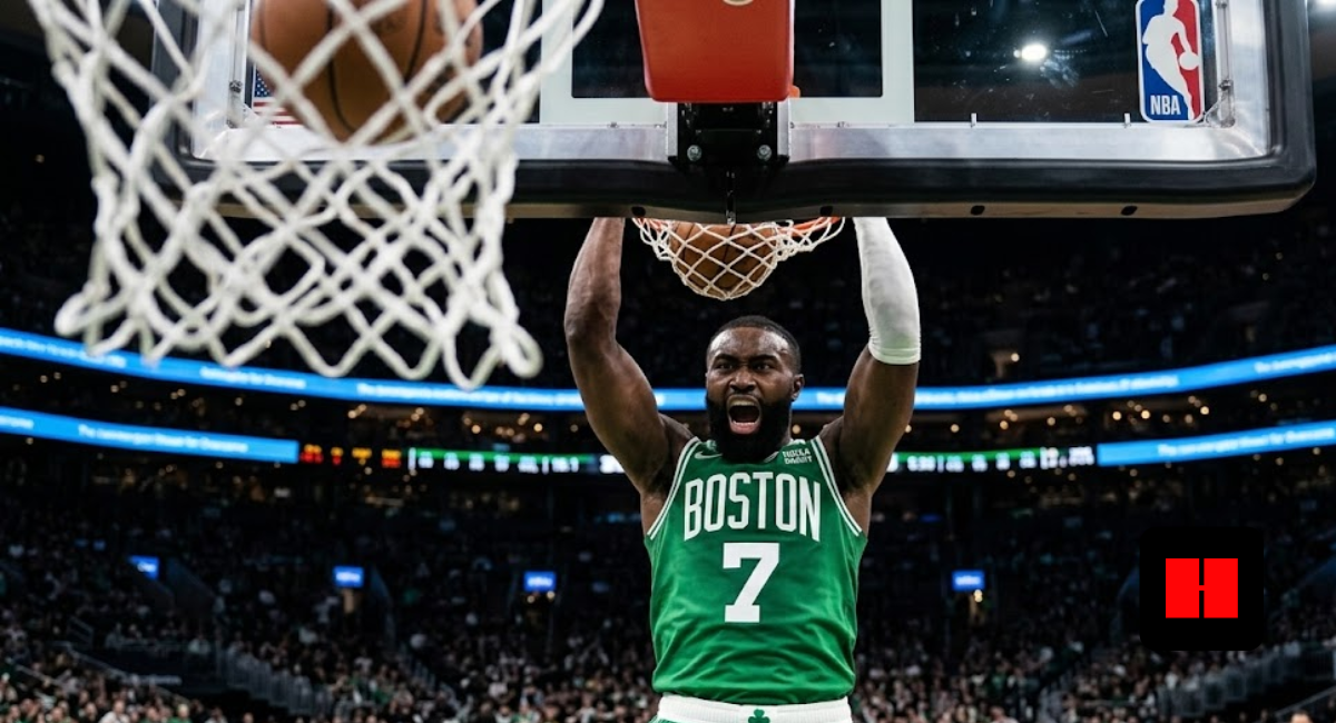 Jaylen Brown of the Boston Celtics screaming after a powerful two-handed dunk in a crowded NBA arena, viewed from under the basket.