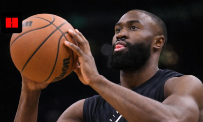 Jaylen Brown preparing to shoot a basketball during Boston Celtics practice with focused expression and blurred background.