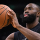 Jaylen Brown preparing to shoot a basketball during Boston Celtics practice with focused expression and blurred background.
