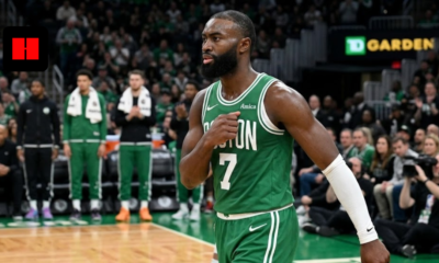 Jaylen Brown of the Boston Celtics wearing a green jersey with number 7, walking on the court at TD Garden during an NBA game.