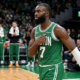 Jaylen Brown of the Boston Celtics wearing a green jersey with number 7, walking on the court at TD Garden during an NBA game.