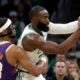 Boston Celtics forward Jaylen Brown protects the basketball while being defended by Phoenix Suns guard Jordan Goodwin during an NBA game.