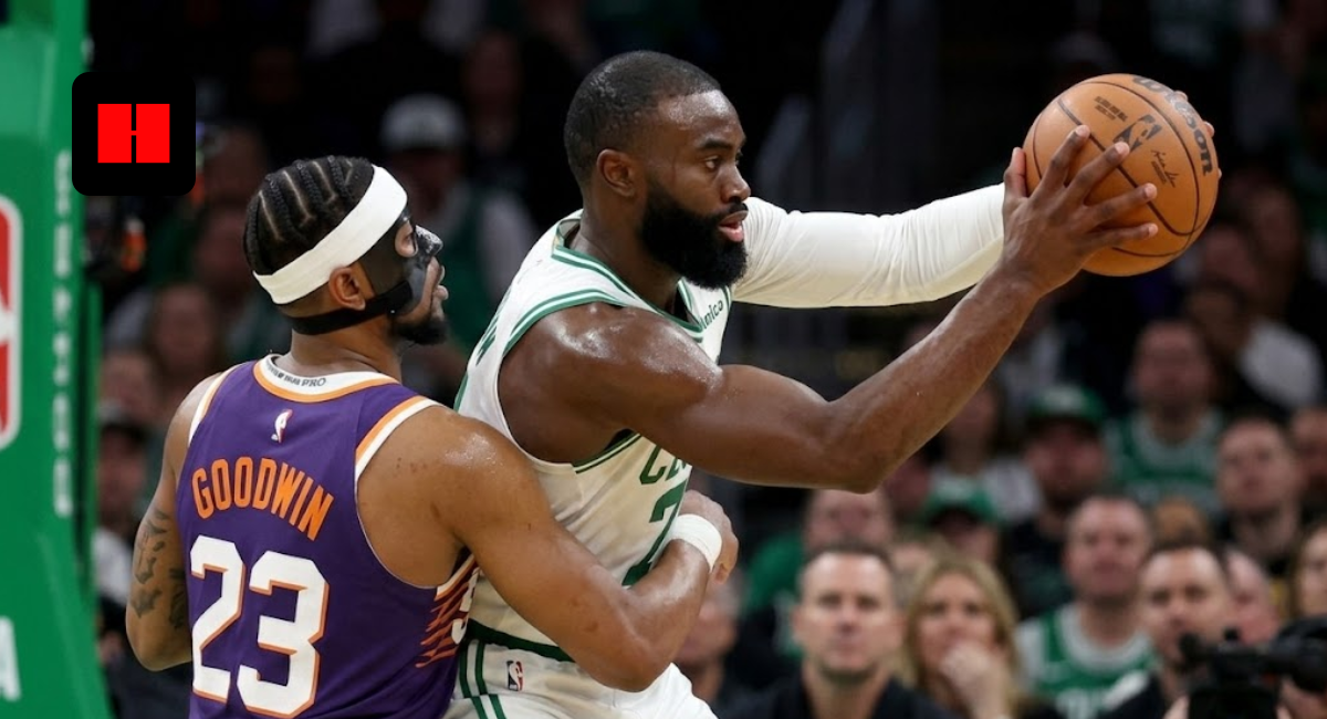 Boston Celtics forward Jaylen Brown protects the basketball while being defended by Phoenix Suns guard Jordan Goodwin during an NBA game.