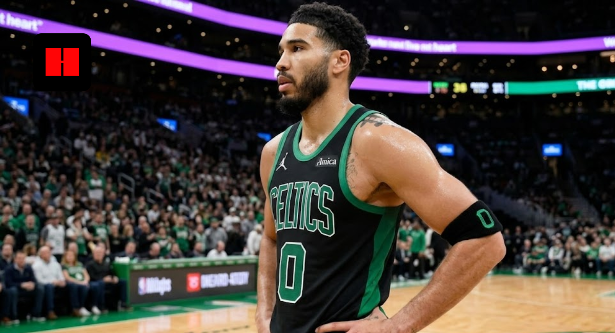 Jayson Tatum standing on the court in a black and green Boston Celtics Statement Edition jersey with hands on hips.