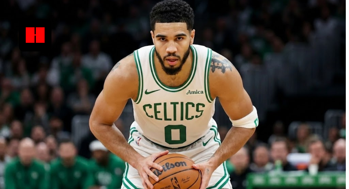 Jayson Tatum of the Boston Celtics wearing a white Association Edition jersey, holding a Wilson basketball and looking focused during an NBA game.