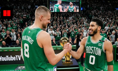Jayson Tatum and Kristaps Porzingis shaking hands on the court in Boston Celtics green jerseys.