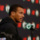 Boston Celtics head coach Joe Mazzulla speaking at a press conference podium with New Balance and team logos in the background.