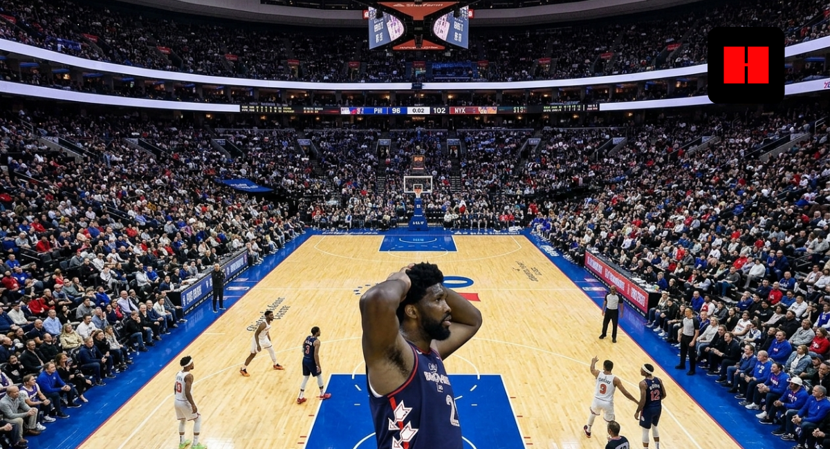 Joel Embiid reacts with hands on head during a late-game moment in a packed Sixers vs Knicks matchup at an indoor NBA arena