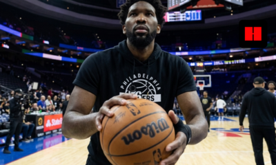 Joel Embiid warming up with a basketball on the Philadelphia 76ers home court before a game, wearing team gear inside the arena in 2026