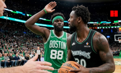 Julius Randle of the Minnesota Timberwolves looking to pass while guarded by Neemias Queta of the Boston Celtics during an NBA game.