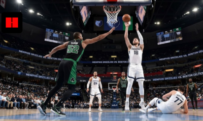 A Memphis Grizzlies player in a white jersey takes a jump shot over a Boston Celtics defender in a black jersey during a high-stakes NBA game at FedExForum.