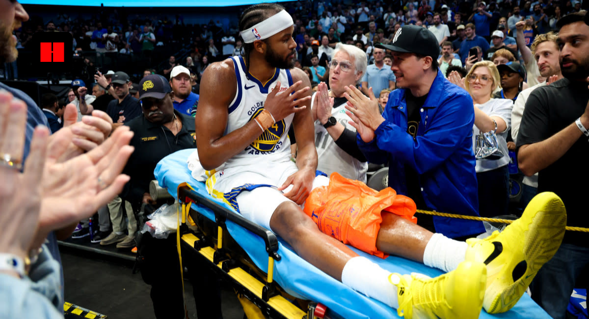 Moses Moody of the Golden State Warriors being helped off the court by trainers after suffering a season-ending knee injury against the Dallas Mavericks.